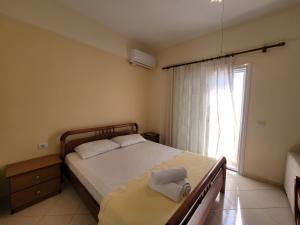 a bedroom with a large bed and a window at Mihasi Apartments in Ksamil