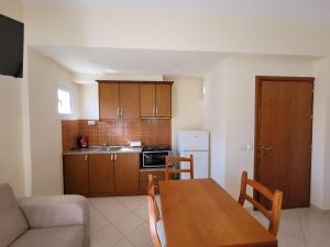 a kitchen and dining room with a table and a couch at Mihasi Apartments in Ksamil