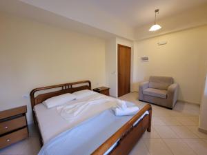 a bedroom with a bed and a chair in it at Mihasi Apartments in Ksamil