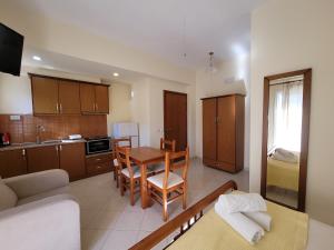 eine Küche und ein Wohnzimmer mit einem Tisch und Stühlen in der Unterkunft Vila Mihasi in Ksamil