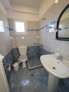łazienka z toaletą i umywalką w obiekcie Vila Mihasi w mieście Ksamil