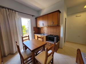 a kitchen and dining room with a table and a microwave at Mihasi Apartments in Ksamil