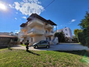 a building with a car parked in front of it at Mihasi Apartments in Ksamil