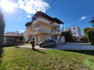 a building with a car parked in front of it at Mihasi Apartments in Ksamil