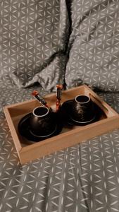 a wooden tray with two cups on a bed at Studio Mišel in Vrnjačka Banja