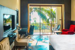 戈卡尔纳Kudle Beach View Resort And Spa Gokarna的一间带床和大窗户的酒店房间