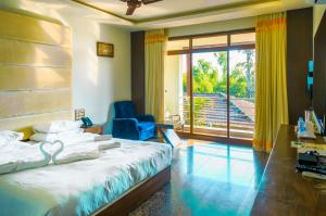 戈卡尔纳Kudle Beach View Resort And Spa Gokarna的一间卧室，里面有一张床、一把椅子和一扇窗户