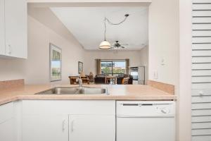 a kitchen with a sink and a living room at Ocean Village Club Q32 in Butler Beach +42 photos