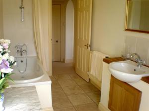 a bathroom with a sink and a tub next to a sink at Higher Faugan in Penzance +38 photos