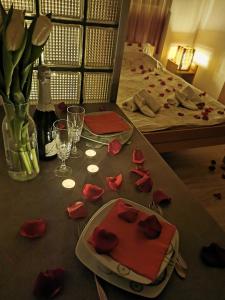 a table topped with red roses on top of a bed at Apartments Take a Break Novi Sad in Novi Sad