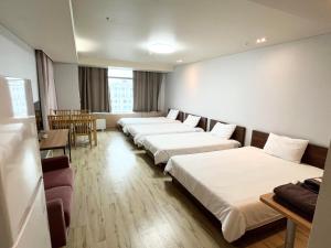 fila de camas en una habitación de hotel en Incheon Airport Guesthouse, en Incheon