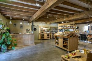 a large room with a store with wooden ceilings at B&B La Ferme de la Patte d'Oie in Saint-Michel-Saint-Jaymes