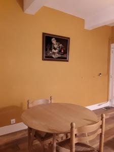 jadalnia ze stołem i zdjęciem na ścianie w obiekcie Deux chambres chez l'habitant w mieście Die