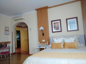 a bedroom with a large white bed with orange pillows at Área de Servicio El Cruce in Manzanares