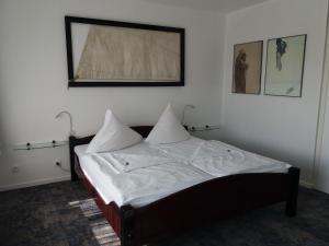 een bed in een kamer met een foto aan de muur bij Hotel Garni Waldsegler in Bad Sachsa +50 foto's