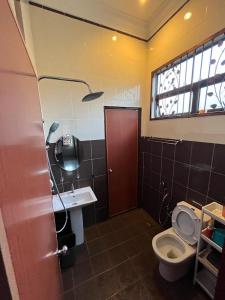 een badkamer met een toilet, een wastafel en een raam bij Sofia Adila Homestay in Hulu Langat