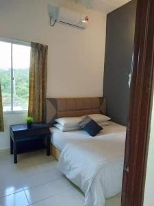een slaapkamer met 2 bedden en een raam bij Belebar Homestay Taman Negara Pahang Malaysia in Kuala Tahan