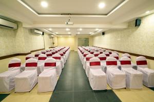 a room with rows of white chairs with red accents at HOTEL THE FORTUNE in Coimbatore