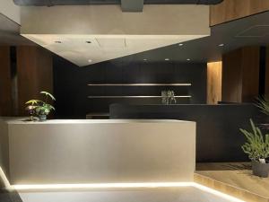 a lobby with a counter with plants on it at R Hotel Namba in Osaka