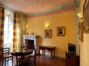 ein Esszimmer mit einem Tisch und einem Kamin in der Unterkunft Antica Residenza del Gallo in Lucca