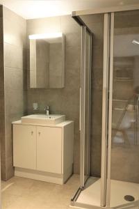 La salle de bains est pourvue d'un lavabo et d'un miroir. dans l'établissement The 109 - Stunning new studios by the lake, close to city center of Lausanne, à Paudex