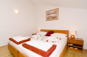 um quarto com uma cama grande e lençóis brancos em Apartments Senjo em Cavtat