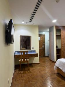 a room with a bed and a television on the wall at Mansour Plaza Hotel Apartments in Dammam