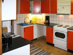 uma cozinha com armários laranja e um forno com placa de fogão em Holiday Home Fågelkärr Sjöstugan by Interhome em Gränna