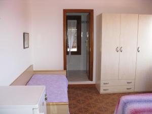 a room with a bed and a closet and a mirror at Apartment Il Seccione-1 by Interhome in Portoferraio