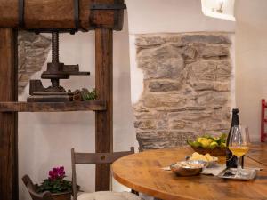 een houten tafel met een fles wijn en een stenen muur bij Apartment Mulino Rossi - PTB170 by Interhome in Pietrabruna +16 foto's