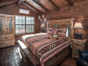 ein Schlafzimmer mit einem Bett in einem Zimmer mit Holzwänden in der Unterkunft Midtown Riverfront 2, 2 Bedrooms, Sleeps 4 in Ruidoso