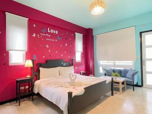 um quarto com uma cama grande e uma parede vermelha em Blue Ocean Sunny BS em Checheng