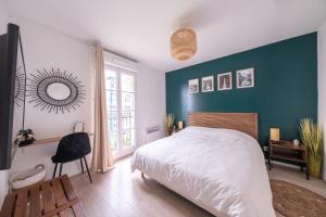ein Schlafzimmer mit einem Bett und einer blauen Wand in der Unterkunft Sérénité proche Disneyland in Serris