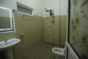 a bathroom with a sink and a shower and a toilet at Milano Grand in Dambulla