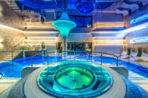 a swimming pool with a hot tub in a building at Villa Collis - Bieszczady in Olchowiec