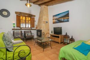 ein Wohnzimmer mit einem Sofa und einem TV in der Unterkunft Can Grever in Llubí