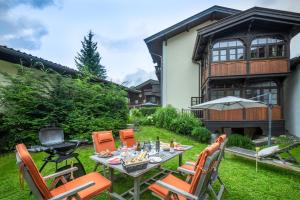 patio ze stołem i krzesłami przed domem w obiekcie STADTVILLA BELLE KITZ im Zentrum mit Sauna by Belle Stay w mieście Kitzbühel