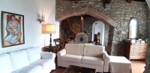a living room with two white couches and a stone wall at Tuvo Agriturismo in Levanto