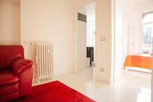 een woonkamer met een rode bank en een bed bij Lambrate Elegant Bright Apartment in Milaan