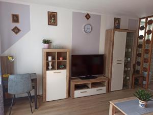 a living room with a television and a table at Apartment Nevela in Bovec