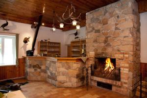 a large stone fireplace in a room with a bar at Penzion Prátr in Třeboň