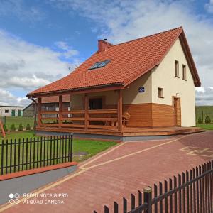 une grande maison avec un toit rouge dans l'établissement Domek letniskowy na Mazurach nad Jeziorem Gawlik, à Wydminy