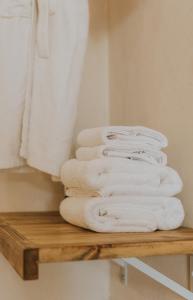 a stack of towels on a wooden shelf in a bathroom at Hotel Anilevich Mansion in Beer Sheva