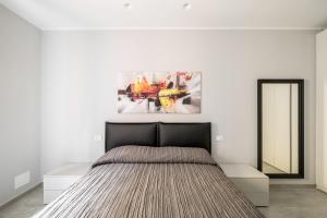 - une chambre avec un lit et une peinture murale dans l'établissement Marsala 19 Apartment by Wonderful Italy, à Bologne
