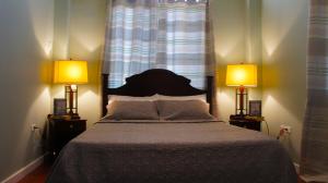 1 dormitorio con 1 cama grande y 2 lámparas en Hampton Apartments Guyana, en Georgetown