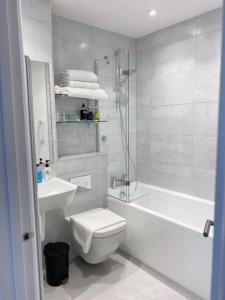 Baño blanco con aseo y lavamanos en Prestbury Bed & Breakfast en Salisbury