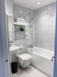 a white bathroom with a toilet and a sink at Prestbury Bed & Breakfast in Salisbury