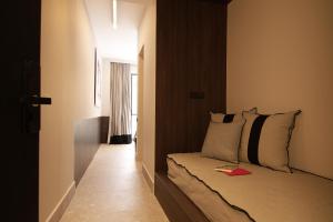 a small bedroom with a bed with a wall at Cityzoe Athens Suites in Athens