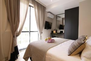 a bedroom with a bed and a window with flowers on it at Cityzoe Athens Suites in Athens