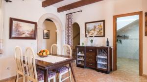 a dining room with a wooden table and chairs at Finca Es Revolt de Sa Barrala in Campos